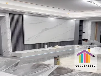 اختلاف درجات اللون يمنح الحائط توازناً بصريًا ويُبرز الأجهزة والإكسسوارات. كلمات دلالية: تباين لوني, خلفية تلفاز, ديكور مودرن, لوح حائط